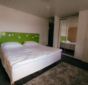 ArtjärviBed and Breakfast Artjärvi的一间卧室配有一张白色床和绿色床头板