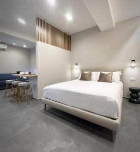 斯培西亚3L Luxury Rooms的卧室配有一张白色的大床和一张桌子