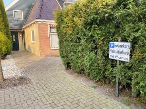 GaastVakantiehuis het Voorhuis op Landgoed koepeltjesplaats的砖车道房屋前的标志