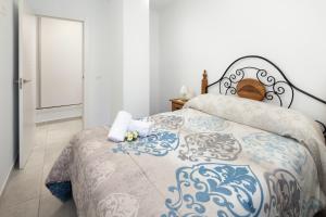 孔佩塔El Monte的一间卧室配有一张带蓝白色毯子的床