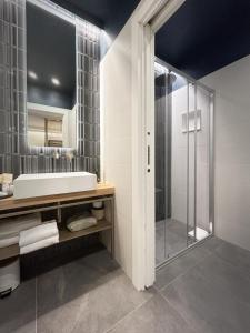 斯培西亚3L Luxury Rooms的带淋浴、盥洗盆和镜子的浴室
