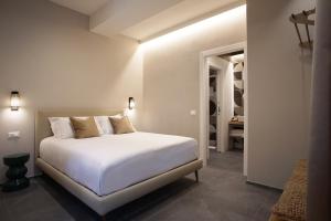斯培西亚3L Luxury Rooms的一间带白色床的卧室和一间浴室
