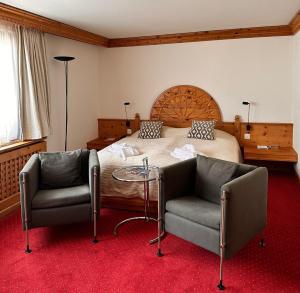 席尔瓦普拉纳阿尔萨洛奇席尔瓦普拉纳酒店的一间卧室配有一张带两把椅子和一张桌子的床。