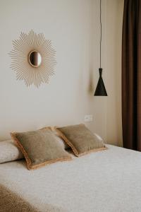托雷德尔马尔Apartamentos Levante - Mares的一间卧室配有一张带两个枕头和镜子的床
