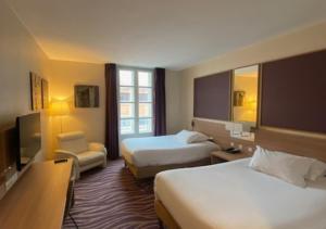 图卢兹Plaza Hotel Capitole Toulouse - Anciennement-formerly CROWNE PLAZA的酒店客房设有两张床和电视。