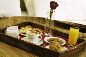 乌斯怀亚乌斯怀亚MIL810酒店的包括早餐食品的托盘和玫瑰花瓶