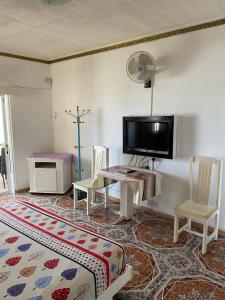 蒙舒瓦西Apartments la Colombe的客厅配有电视和桌椅