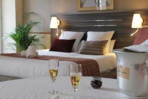 吕克瑟伊莱班HOTEL CERISE - LES SOURCES Luxeuil-les-Bains的在酒店房间桌子上放两杯香槟