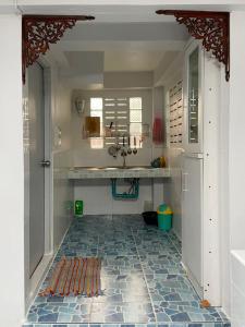 清莱Tintin home的厨房铺有瓷砖地板,配有水槽。