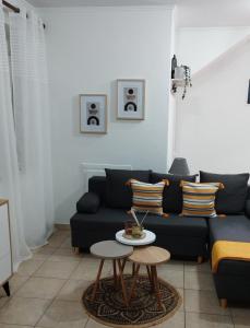 萨索斯La bella casa thassos的客厅配有黑色沙发和桌子
