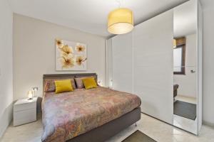 卡洛福泰Ca' Alessandra的一间卧室配有一张带黄色枕头的大床