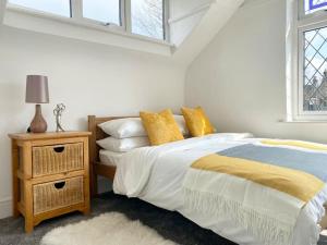 滨海绍森德Charming Seaside Cottage in Leigh-on-Sea的一间白色卧室,配有床和床头柜