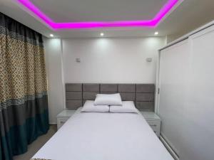 沙姆沙伊赫Beautiful 1 Bedroom apartment in el Montazah的一间卧室配有一张紫色照明床