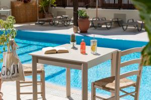 伊利索斯GOJI Vegan Hotel的游泳池畔的一张桌子和两把椅子