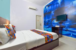 斋浦尔FabExpress Green Vista的一间卧室配有一张蓝色墙壁的床