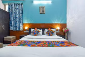 斋浦尔FabExpress Green Vista的一间卧室配有一张特大号床和五颜六色的被子