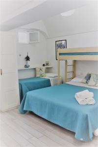 阿纳卡普里La Maiolica的一间卧室配有蓝色的床和毛巾