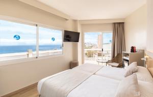 马盖鲁夫萨默斯酒店的一间卧室设有一张大床和一个大窗户