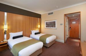 伦敦皇冠假日伦敦伊灵酒店的一间酒店客房,设有两张床和一扇门