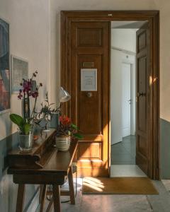 那不勒斯Carafa Suite By Enjoy Napoli的走廊上设有桌子和木门