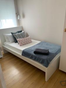 马德里Apartamento Vallecas Plaza的一张带蓝色毯子和枕头的白色床