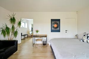 奥纲赖泽Villa Terlanen的一间卧室配有一张床、一张沙发和一张桌子