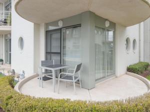 米斯堡Apartment Estepona by Interhome的大楼前带桌椅的天井