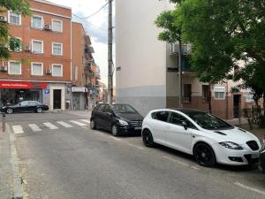 马德里Apartamento Vallecas Plaza的两辆白色汽车停在街道边