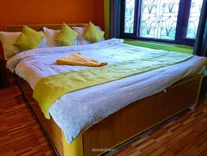 索拉哈Hotel Butterfly , Sauraha , Chitwan的一张带黄色和白色床单的床和窗户