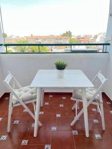 桑卢卡尔-德巴拉梅达Apartamento GUADALQUIVIR的阳台上配有一张白色的桌子和两把椅子