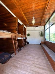 珀尼达岛Penida Hills Hostel的一间设有木墙和吊灯的天花板的客房