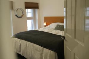 梅瑟蒂德菲尔Charming 1-Bed & balcony Flat in Merthyr Tydfil的一间卧室配有一张带黑色毯子的床和窗户。