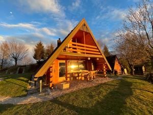 卡姆尼克Mountain view cottage的草上带三角形屋顶的小屋