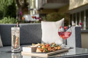 梅拉诺Hotel Mignon Meran Park & Spa的一张桌子,上面放着一杯葡萄酒和一盘食物