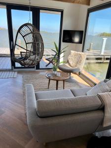 蒙尼肯丹Luxury Houseboat Liberdade with sauna and dinghy的客厅配有沙发和椅子