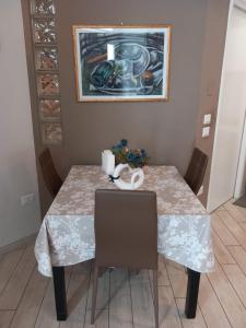 特拉尼Il faletto的一张餐桌,配有两把椅子和一幅画
