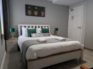 基拉尼Kingdom Lodge的一间卧室配有一张带绿色枕头的大床