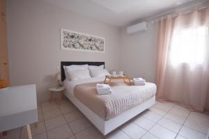 马科普隆K&C Rooms- Apartments的一间卧室配有带毛巾的床