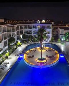 迪迪姆AKBÜK Palace Resıdence的享有带游泳池的大楼的夜间景致