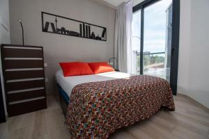 马德里Ekilibrio Hotel & Apart-Suites的一间卧室配有带橙色枕头的床和窗户。