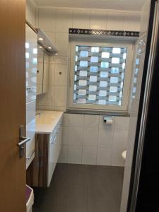 施内沃丁根Marina, Ferienwohnung的白色的浴室设有水槽和窗户。