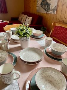 拉姆绍达赫斯坦Landhaus Birgbichler - Apartments mit Bergblick inklusive Sommercard的桌子上放有盘子和杯子,花朵