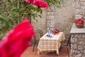 圣安格塔苏德格尔夫Antico Casale Ruoppo的桌子和椅子,上面有桌子和鲜花