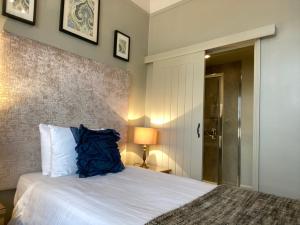克罗默弗吉尼亚州庭院酒店的一间卧室配有一张带蓝色枕头的床