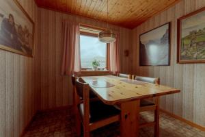 3-Bedroom Home in Eiði的一间带木桌和窗户的用餐室