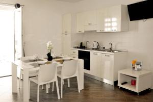 奥特朗托MARIMAR - Apartments OTRANTO的白色的厨房配有桌椅和柜台。
