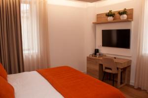 米兰德拉Coração do Tua Hotel的酒店客房配有一张床和一张书桌及一台电视
