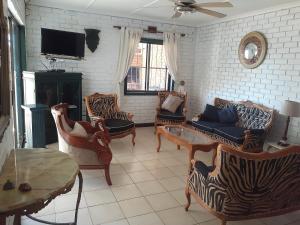 圣卢西亚Turtleshaven的客厅配有椅子、沙发和电视