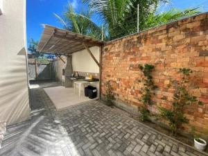 德奥多鲁元帅镇Apartamento na Massagueira, 3km Praia do Francês的一个带砖墙和桌子的庭院