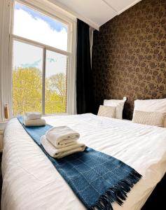 阿姆斯特丹阿姆斯特丹酒店的一张带毛巾的床和窗户